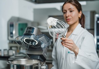 Whipped protein foam on the stirrer of a stirring machine, which is visually checked for stability by a scientist